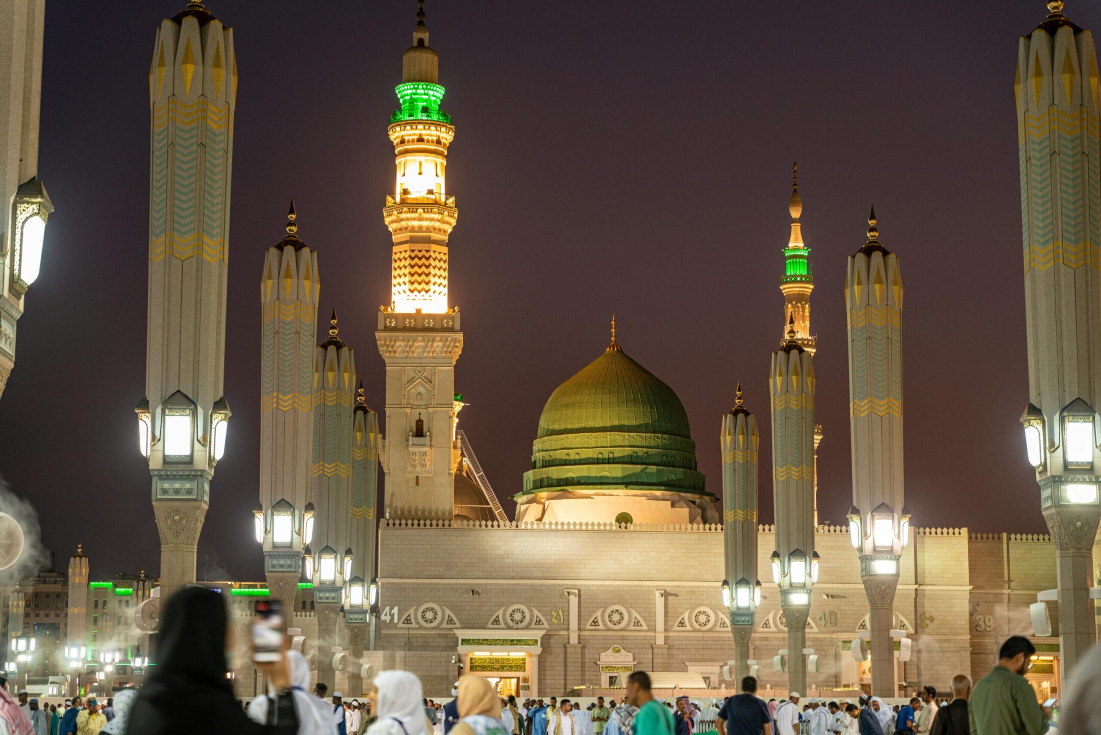 Stunning illuminated night view of Al-Masjid an-Nabawi, a prominent Islamic worship site in Medina.